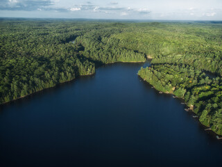 Buckskin Lake on a late summer afternoon. Aerial above the expansive crown land evergreen wilderness in Tory Hill, Highlands East, Ontario, Canada. © Atomazul