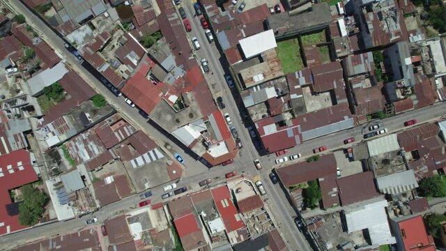 Drone aerial footage of central american urban city streets with usual foot and car traffic in Quetzaltenango, Xela, Guatemala. 2a Calle y 19 Avenida. Daytime. 
