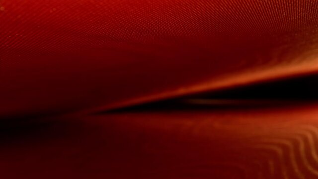 RACK FOCUSING diagonal section of equally spaced top and bottom decorative endpapers of a book. Lit camera right, top and bottom form V-shape, DEFOCUSING right to left and back to crest of the V