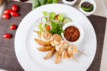 chicken skewers with grilled potatoes and tomato spicy sauce
