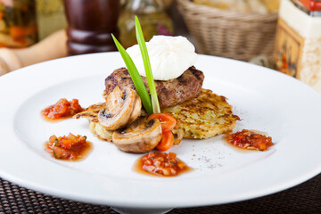 beef cutlet with egg benedict with fried potatoes, mushrooms and spicy sauce
