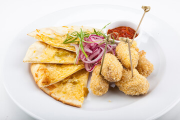 appetizer breaded chicken with tortillas and spicy tomato sauce and onions
