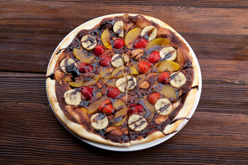 fruit pizza with banana berries and chocolate sauce
