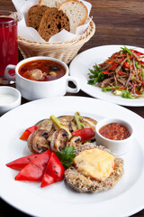 business lunch schnitzel with fried mushrooms and sweet pepper with hodgepodge, salad
