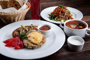business lunch schnitzel with fried mushrooms and sweet pepper with hodgepodge, salad
