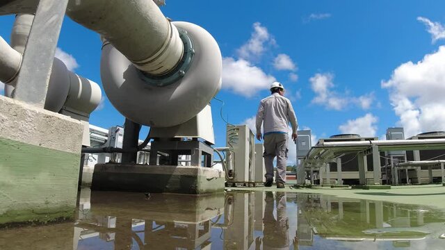 Service engineer to check the air condition system on the rooftop of building