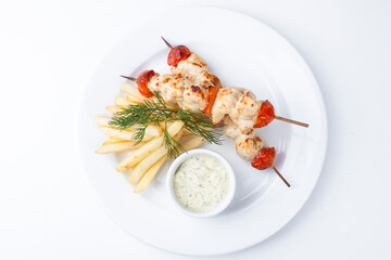 chicken skewer with French fries and white sauce