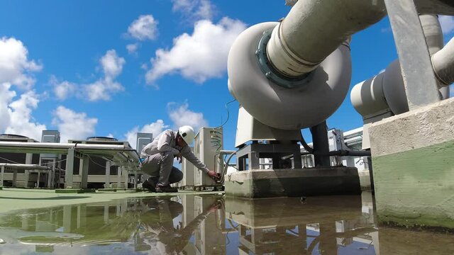 Service engineer to check the air condition system on the rooftop of building