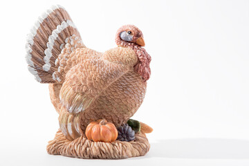 Vintage clay turkey against a white background. Seasonal display for Thanksgiving and Halloween.