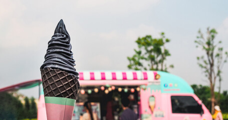 yogurt charcoal or black sesame ice cream on cone with vintage sweet pastel color food truck background, copy space - Powered by Adobe