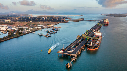 Aerial view of  coal ship and wharf with coal piles in the background