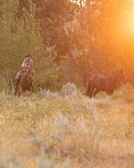 Cowgirl wrangling horses