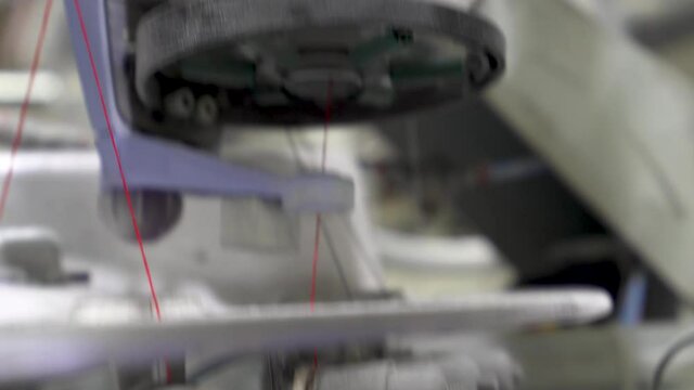 4K clip of Industrial machine unwinding nylon spool in sock making process