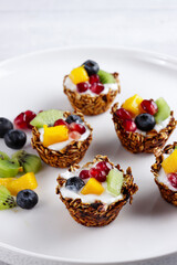 Nutritious granola cups filled with yoghurt and fruits.