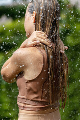 Girl in the rain. Young beautiful girl with splashing water. High quality photo