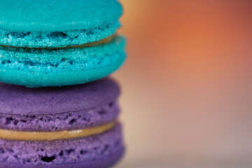 Delicious macaroons, a famous multicoloured French dessert in a stack. Selective focus. Blurred background