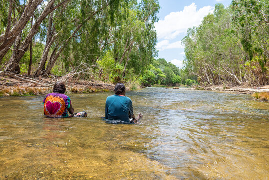 Aboriginal people sitting in river