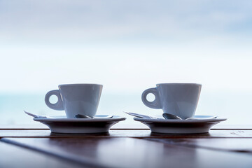 two cups of coffee on wooden table isolated on light background