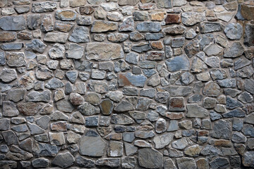 An old wall of natural material made of granite blocks 