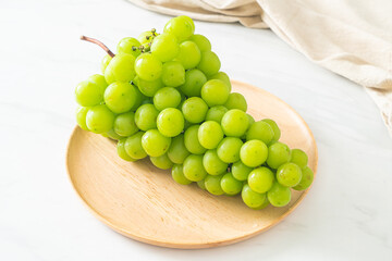 fresh green grape on wood plate