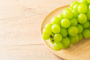 fresh green grape on wood plate