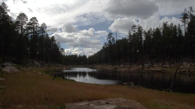 Clouds rolling in over a canyon river with wind sending ripples through the water.