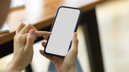 Close up, selective focus on female hands using smartphone in blurred background