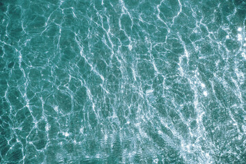 Green water and pouring mica through a layer of glitter water. A backdrop of the sea and ocean depth