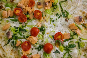 Pizza background. Pizza on pita with white sauce, lettuce, salmon and cherry tomatoes