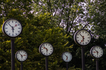 Classic black and white analog clocks with synchronized time show teamwork and synced project management with time management and deadlines in international teams running out of time ticking clocks