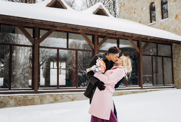 Amazing couple hugging and kissing outdoors in winter. Couple posing near a beautiful building....