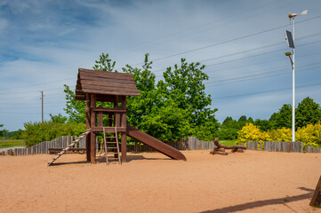 Children's playground equipped with wooden slides. A modern children's slide made of wood and natural materials.
