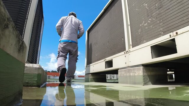 Service engineer to check the air condition system on the rooftop of building