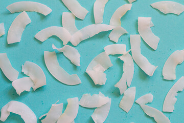 Background of dried coconut white chips on a blue background