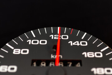 Car speedometer with the needle pointing a high speed at blackground, Speedometer with a red arrow indicating speeding, conceptual image for excessive speeding or careless driving concept.Close-up.