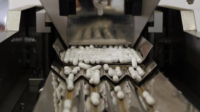 Pharmaceutical production. Medical capsules are moving in a packaging machine.