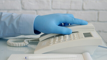 Man Wearing Protection Gloves in Hands Using Telephone. Landline Communication Used in Hospital.