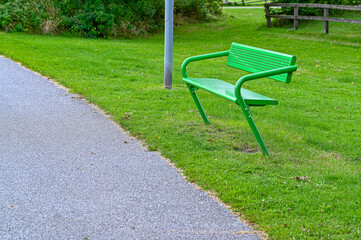 Green painted metal bench in public park