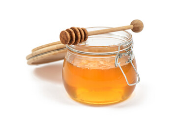 Jar of honey with honey dipper  on white background.