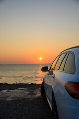Fototapeta na wymiar Auto im Sonnenuntergang am Meer