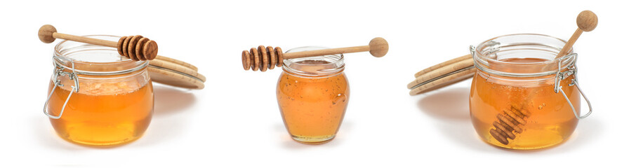 Jars of honey with honey dippers  on white background.