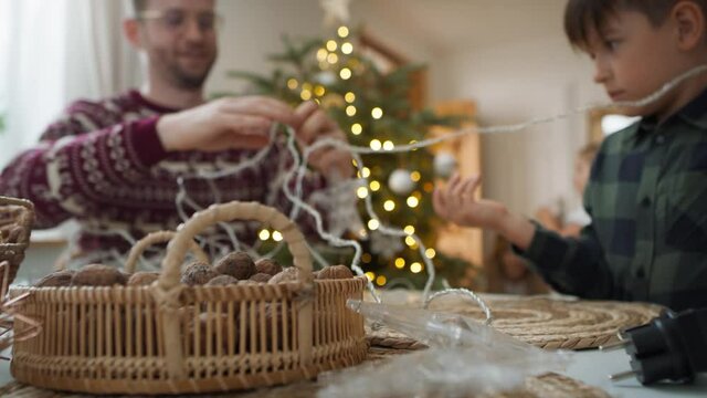 Dad with son trying to untangle the cable with the light. Shot with RED helium camera in 8K 