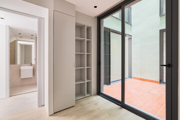 Interior of modern empty room in refurbished apartment with big black frame of windows, wardrobe...