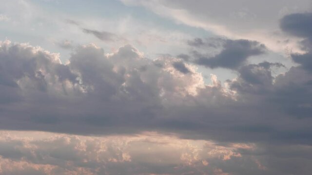 Beautiful pastel sky with gray clouds slowly moving. Dramatic clouds at sunset.