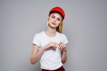 cheerful pretty woman in red cap posing summer yellow earrings