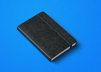 black closed notebook isolated on blue