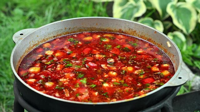 Hungarian traditional bograch. Making stew on open fire. german comfort food. Traditional Hungarian Goulash in cauldron. Transcarpathian dish. Soup with meat and paprika. Eintopf, chili con carne.