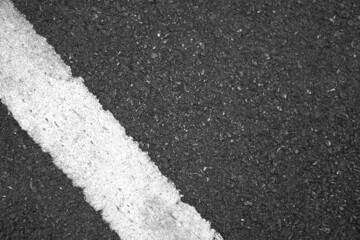 Fototapeta premium Surface rough and wet of asphalt after the rain, Grey with white line on the road and small rock, Texture Background, Top view
