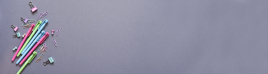 Back to school. School supplies: notebook, pen, pencil on a gray background. Baner. View from above. Office tools.