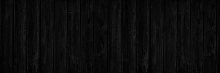 Dark wood background with copy space for design. Wide banner. Black wooden planks.	